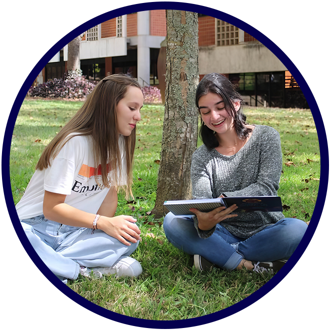Dos estudiantes leyendo juntas al aire libre en el campus